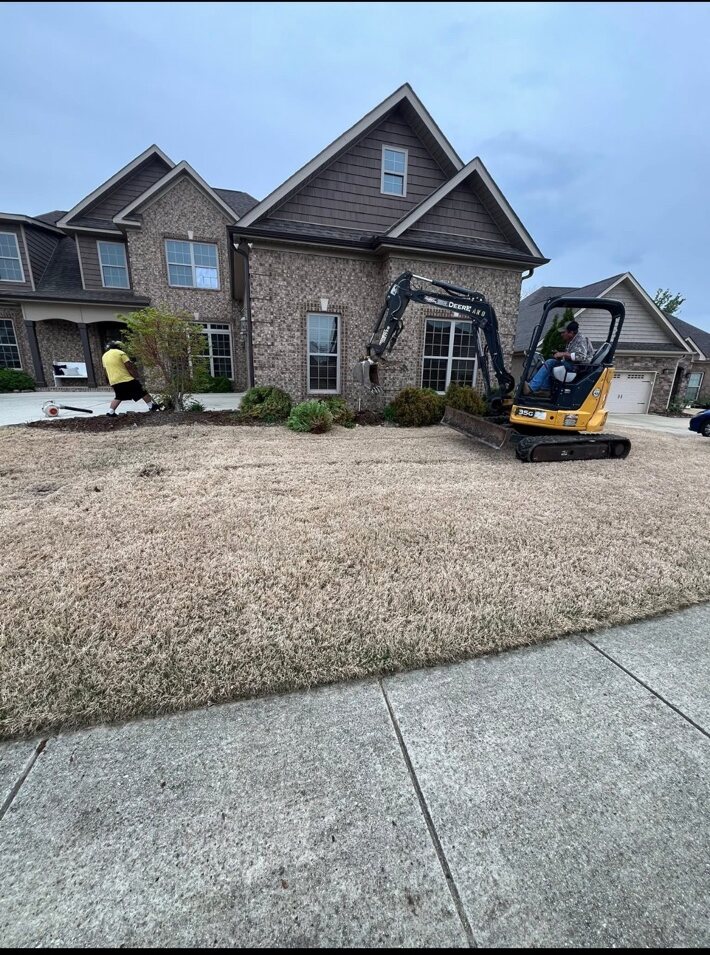 Bates Lawn Care crew using a mini excavator during a residential landscape project