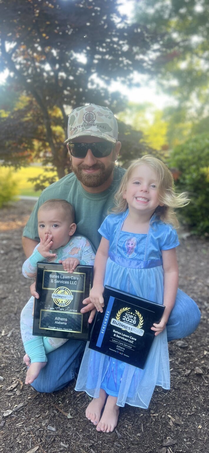 Bates Lawn Care owner with his children holding Top 5 Athens lawn care awards for 2025 and 2026